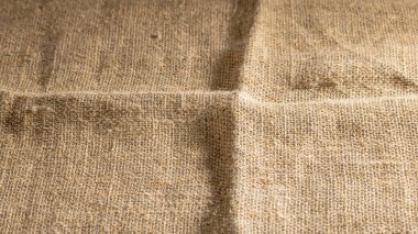 Yan ışıkla aydınlatılmış eski kaba çuval bezinin arka planı.