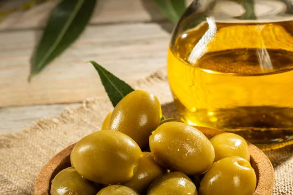 Çuval bezi üzerinde yeşil zeytinyağı ve bir sürahi zeytin yağı..