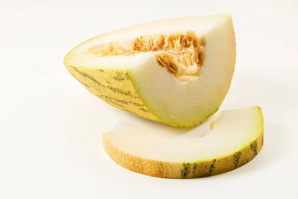 Sliced melon and melon slice on white background closeup.