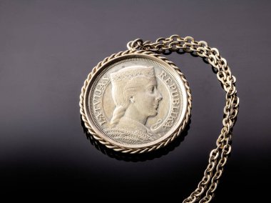 Letonya, Daugavpils, 2 Ağustos 2023. Letonya gümüş sikkesi 5 lats 1931 obverse tarafı siyah ayna arka planı. Madeni para gümüş zincirli bir madalyon şeklinde yapılmıştır..