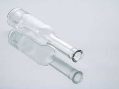 Yan yatmış şeffaf bir cam şişe ayna arka planına güzelce yansıtılır..