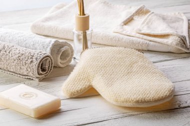 Banyo içi. Terry havlular, masaj eldiveni ve lamba masasında sabun. Minimalizm, yüksek anahtar