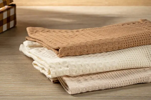 Waffle havluları ahşap bir masanın üzerinde katlanmış, üst manzara. Ev Hayatı