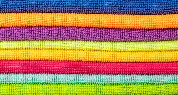 Parlak mikrofiber peçetelerin arka planı bir yığın halinde katlanmış. Kapat.
