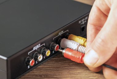 Bir fişi renk müzik yükselticisine bağlayan yakın plan el.