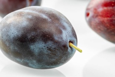 Beyaz arka planda olgun mor erik..