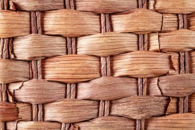 Çikolata renkli kamış hasırından yapılmış parlak desenli bir arka plan. Kapat.