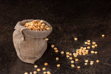 Yakından çekilmiş, parlak siyah bir arkaplana yerleştirilmiş yeşil bezelyeli bir yemek fotoğrafı. Taze üretimin canlı renkleri ve dokuları büyüleyici bir görsel kompozisyon oluşturuyor..