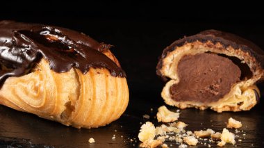 Karanlık bir arka planda sergilenen lezzetli bir bütünün ve yarı yarıya ekinlenmiş pastaların yakın çekimi. Yemek blogları, fırın reklamları ya da mutfak kavramları için mükemmel..