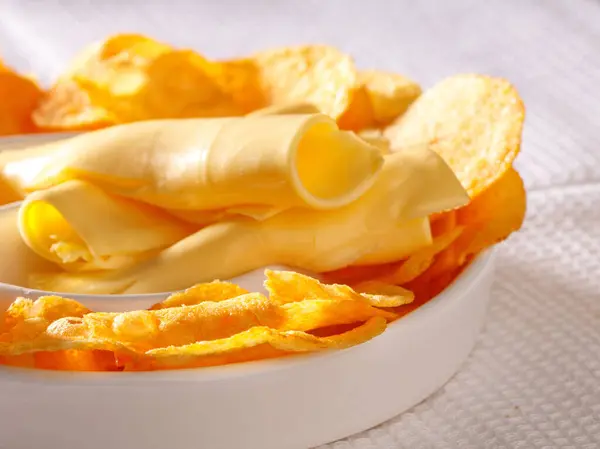 Cips ve peynirli tabak, yakın plan, beyaz arkaplan.