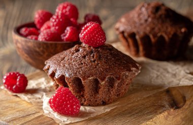 Lezzetli taze çikolatalı kekler, üzerinde canlı olgun ahududular var. Renk ve lezzetlerle baştan çıkarıcı bir tezat oluşturuyor. Tatlı ya da tatlı için mükemmel.