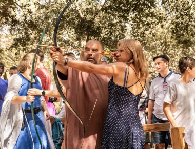 Kudüs, İsrail, 24 Eylül 2022: İsrail 'in Kudüs kentindeki Ein Yael Müzesi' nde düzenlenen festivale katılan bir katılımcının rehberliğinde okçuluk eğitimi alan bir ziyaretçi