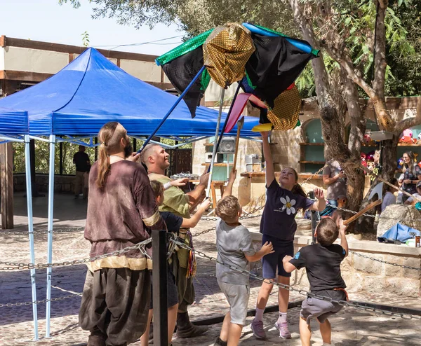 stock image Jerusalem, Israel, September 24, 2022 : Participants of the festival in medieval clothes with a large dragon in their hands play with children at the Knights of Jerusalem festival at the Ein Yael Museum, in Jerusalem, Israel