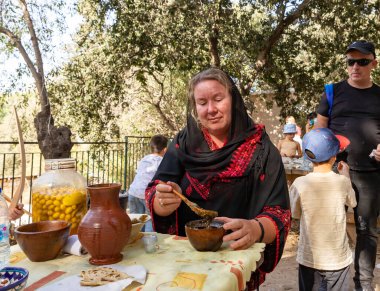 Kudüs, İsrail, 24 Eylül 2022: Bir katılımcı, İsrail 'in Kudüs kentindeki Ein Yael Müzesi' ndeki Knights of Jerusalem Festivali 'nde tahta kaşıkla kil bir kasede baharat karıştırıyor.