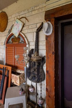 Nahariya, İsrail, 21 Ekim 2022: Bahçe Almona koleksiyonunda sergilenen evin verandasında, batan güneşin ışınlarında, kuzeydeki Julis Druze köyünde dekoratif süslemeler