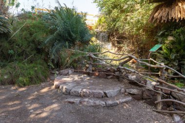 Eilat, Israel, December 13, 2022 : Small decorative waterfall on the territory of the Botanical Garden in the Eilat city, southern Israel