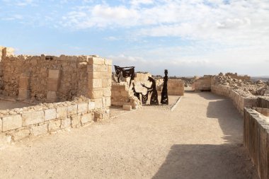 Mitzpe Ramon, Israel, December 14, 2022 : Abstract figure of seller and buyers made of iron near ruins of city - fortress of Nabateans Avdat, on trade route called Way of Incense, near Mitzpe Ramon city, in southern Israel