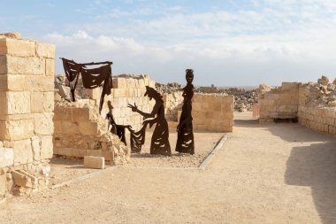 Mitzpe Ramon, Israel, December 14, 2022 : Abstract figure of seller and buyers made of iron near ruins of city - fortress of Nabateans Avdat, on trade route called Way of Incense, near Mitzpe Ramon city, in southern Israel