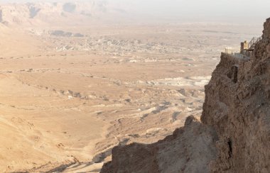 View during sunrise from the ruins of the fortress wall of the fortress of Masada to the ruins of the palace of King Herod and to the adjacent valley, in southern Israel