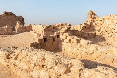 The remains of internal buildings in the rays of the rising sun in the ruins of the fortress of Masada - is a fortress built by Herod the Great on a cliff-top off the coast of the Dead Sea, in southern Israel