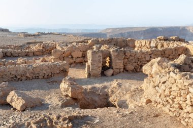 The remains of internal buildings in the rays of the rising sun in the ruins of the fortress of Masada - is a fortress built by Herod the Great on a cliff-top off the coast of the Dead Sea, in southern Israel