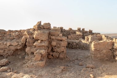 The remains of internal buildings in the rays of the rising sun in the ruins of the fortress of Masada - is a fortress built by Herod the Great on a cliff-top off the coast of the Dead Sea, in southern Israel
