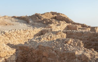 The remains of internal buildings in the rays of the rising sun in the ruins of the fortress of Masada - is a fortress built by Herod the Great on a cliff-top off the coast of the Dead Sea, in southern Israel