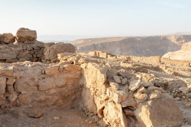 The remains of internal buildings in the rays of the rising sun in the ruins of the fortress of Masada - is a fortress built by Herod the Great on a cliff-top off the coast of the Dead Sea, in southern Israel