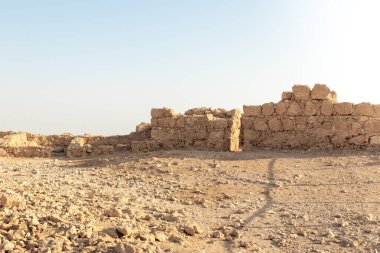 The remains of internal buildings in the rays of the rising sun in the ruins of the fortress of Masada - is a fortress built by Herod the Great on a cliff-top off the coast of the Dead Sea, in southern Israel
