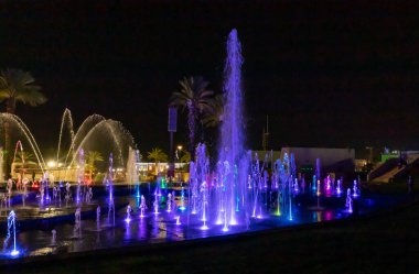 Eilat, Israel, December 13, 2022 : Enchanting grandiose musical performance - water and light show of a musical fountain on the embankment, in the center of the city of Eilat in southern Israel