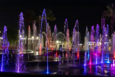 Eilat, Israel, December 13, 2022 : Enchanting grandiose musical performance - water and light show of a musical fountain on the embankment, in the center of the city of Eilat in southern Israel