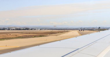 Tel Aviv-Yafo, İsrail, 16 Mart 2023: Bir Flydubai uçağının penceresinden Dünya Havayolları 'nın ayakta duran uçaklarına ve İsrail' deki Ben Gurion Havaalanı 'ndaki havaalanı binasına bakın.