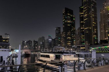 Dubai, Birleşik Arap Emirlikleri, 16 Mart 2023: Dubai limanından gece manzarası aydınlık gökdelenler, bir su kanalı, yatlar ve gemiler Dubai şehrinde, Birleşik Arap Emirlikleri