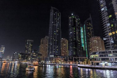 Dubai, Birleşik Arap Emirlikleri, 16 Mart 2023: Dubai limanından gece manzarası aydınlık gökdelenler, bir su kanalı, yatlar ve gemiler Dubai şehrinde, Birleşik Arap Emirlikleri