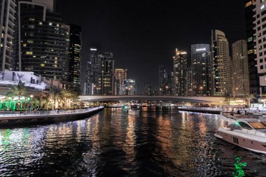 Dubai, Birleşik Arap Emirlikleri, 16 Mart 2023: Dubai limanından gece manzarası aydınlık gökdelenler, bir su kanalı, yatlar ve gemiler Dubai şehrinde, Birleşik Arap Emirlikleri