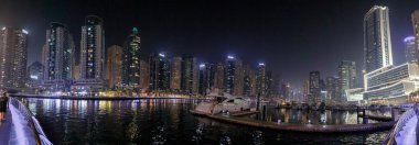 Dubai, Birleşik Arap Emirlikleri, 16 Mart 2023: Dubai limanından gece manzarası aydınlık gökdelenler, bir su kanalı, yatlar ve gemiler Dubai şehrinde, Birleşik Arap Emirlikleri