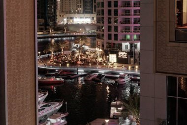 Dubai, Birleşik Arap Emirlikleri, 17 Mart 2023: Dubai limanından gece manzarası aydınlık gökdelenler, bir su kanalı, yatlar ve gemiler Dubai şehrinde, Birleşik Arap Emirlikleri