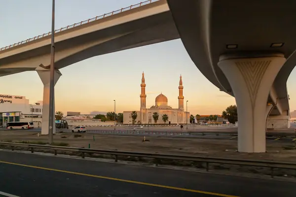 Dubai, Birleşik Arap Emirlikleri, 18 Mart 2023: Gün batımında El Khair Mescid camii ve Birleşik Arap Emirlikleri kentinin diğer mimarisi olan El Khair Mescid 'in penceresinden gün batımına bakın