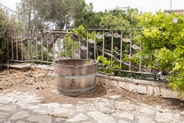 Eski ahşap bir fıçı ve İsrail 'in kuzeyindeki Hayfa yakınlarındaki ünlü sanatçı Ein Hod köyünde yerel bir sanatçı tarafından balıkla süslenmiş metal bir çit.