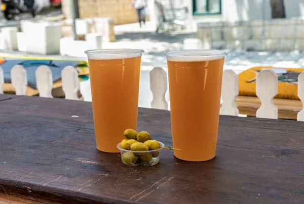 Dois Copos Plástico Meio Litro Com Cerveja Artesanal Frasco Azeitonas — Fotografia de Stock