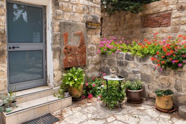 Hayfa, İsrail, 3 Haziran 2023: İsrail 'in kuzeyindeki Hayfa yakınlarındaki ünlü sanatçı köyü Ein Hod' da yerel sanatçıların ürünleriyle süslenmiş taş duvar