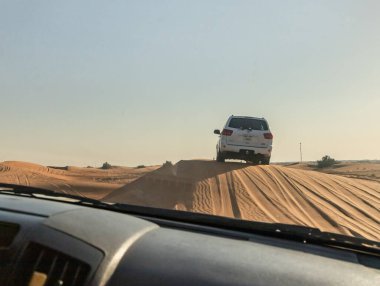 Dubai, Birleşik Arap Emirlikleri, 20 Mart 2023: Toyota beyaz kapalı jipinin penceresinden görünen manzara Dubai şehri yakınlarındaki kumlu çölden geçiyor, Birleşik Arap Emirlikleri.
