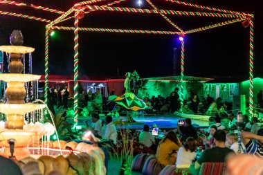 Dubai, Birleşik Arap Emirlikleri, 20 Mart 2023: Sahnedeki dansçı, Dubai 'de, Birleşik Arap Emirlikleri yakınlarındaki kumlu çölde, Macera Gezegeni Turizminde geleneksel Arap performansını sergiliyor.