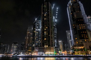 Dubai, Birleşik Arap Emirlikleri, 21 Mart 2023: Dubai limanından gece manzarası aydınlık gökdelenler, bir su kanalı, yatlar ve gemiler Dubai şehrinde, Birleşik Arap Emirlikleri