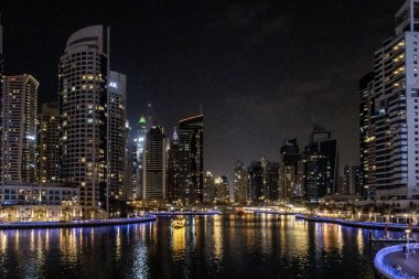 Dubai, Birleşik Arap Emirlikleri, 21 Mart 2023: Dubai limanından gece manzarası aydınlık gökdelenler, bir su kanalı, yatlar ve gemiler Dubai şehrinde, Birleşik Arap Emirlikleri