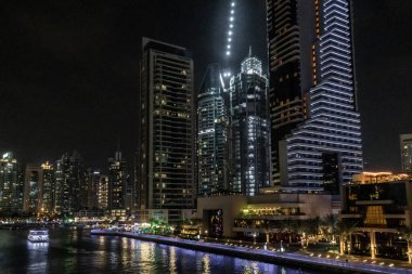 Dubai, Birleşik Arap Emirlikleri, 21 Mart 2023: Dubai limanından gece manzarası aydınlık gökdelenler, bir su kanalı, yatlar ve gemiler Dubai şehrinde, Birleşik Arap Emirlikleri