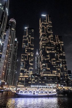 Dubai, Birleşik Arap Emirlikleri, 21 Mart 2023: Dubai limanından gece manzarası aydınlık gökdelenler, bir su kanalı, yatlar ve gemiler Dubai şehrinde, Birleşik Arap Emirlikleri