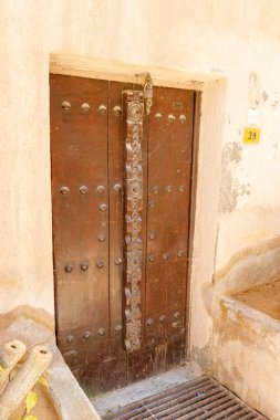 Dubai, Birleşik Arap Emirlikleri, 22 Mart 2023 Dubai, Birleşik Arap Emirlikleri 'nin Dubai şehrinin yeniden inşa edilmiş eski bölümündeki binada süslemeli büyük ahşap perçinlenmiş kapı.