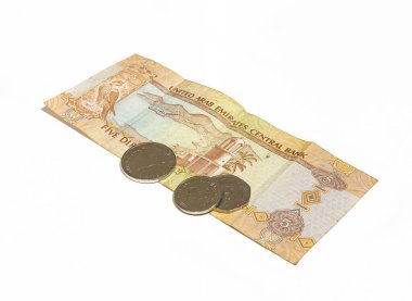 Birleşik Arap Emirlikleri Ulusal Bankası 'nın beş dirhem ve birkaç madeni parasından oluşan bir banknot beyaz arka planda