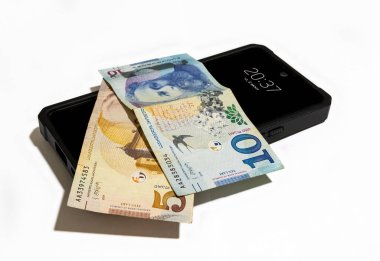 Gürcistan Merkez Bankası 'nın beş ve on Lari' lik banknotları ve beyaz arka planda siyah bir cep telefonu.